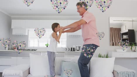 Animation-of-happy-caucasian-grandfather-and-granddaughter-jumping-on-sofa