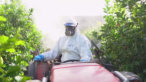 farmer in protective clothes spray pesticides