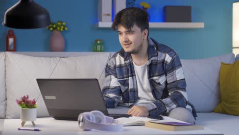 hombre viendo una película en la computadora portátil por la noche en casa.