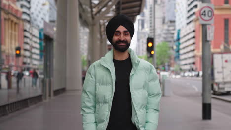 young indian punjabi sikh man looks to the camera then smile