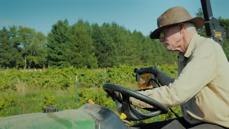 the farmer in the hat works on a small tractor