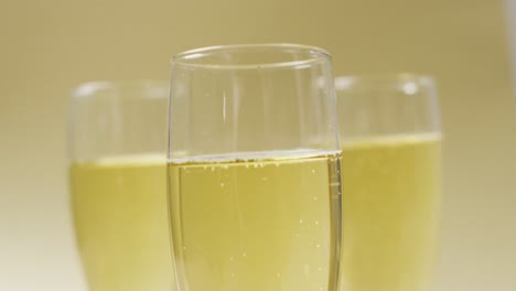 video of champagne in glasses on yellow background