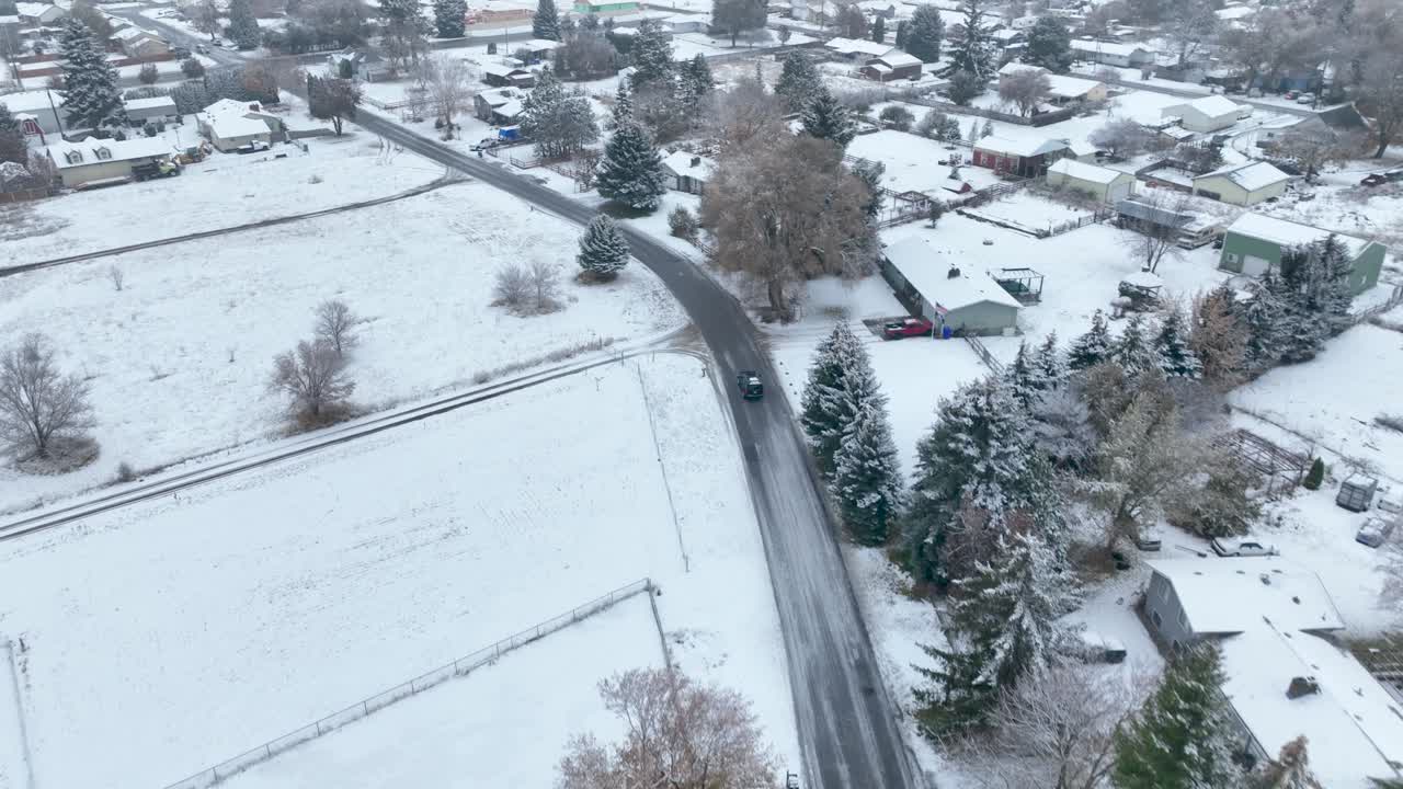 눈이 온통 미국 시골을 운전하는 어두운 차를 추적하는 드론 샷