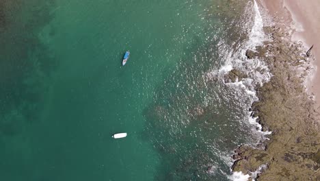 Vista-Aérea-De-Arriba-Hacia-Abajo-De-Dos-Barcos-De-Pesca-Flotando-Con-La-Marea-En-La-Costa-De-Costa-Rica