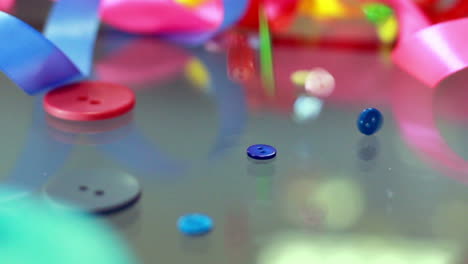 sewing buttons falling on glass table. closeup. sewing supplies