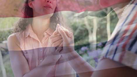 holding hands and smiling, two women with transgender pride flag animation over