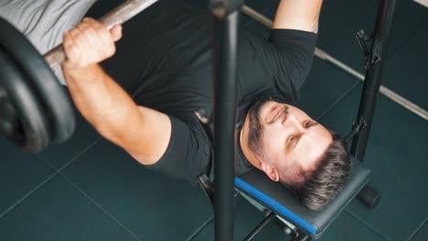 Joven-Fuerte-Entrenando-Ejercicio-De-Press-De-Banca-En-El-Gimnasio