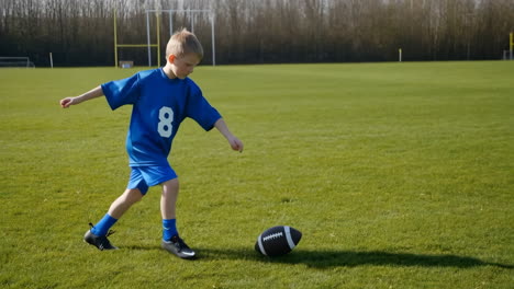 young boy in blue uniform playing american football on a green field