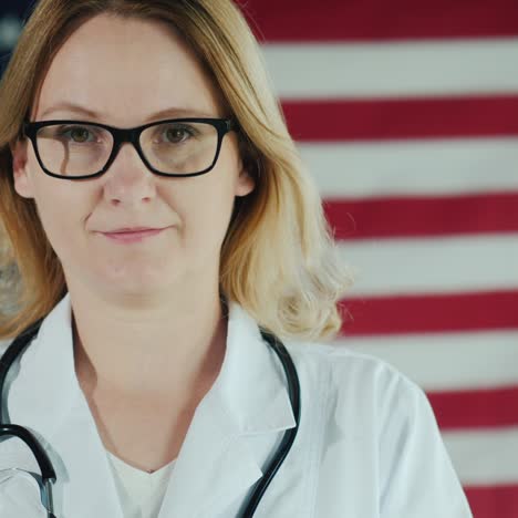 Attractive-Female-Doctor-Looks-Into-Camera-Amid-Us-Flag