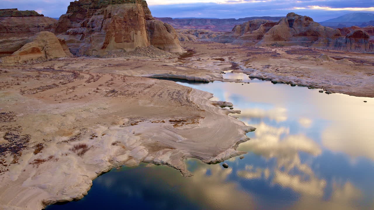 A cinematic drone perspective capturing the breathtaking red rock landscapes surrounding Lake Powell.