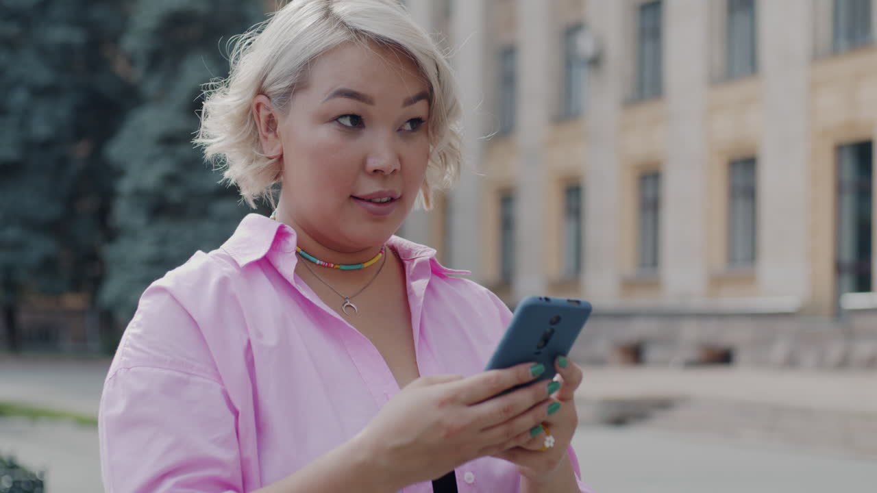 Plus-size woman using a smartphone outdoors