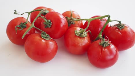 la mano de un bebé alcanzando tomates de cereza frescos
