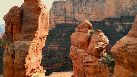 drone flying through epic red rock stone spires revealing capitol butte in sedona