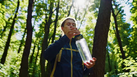 person hiking and drinking water in the forest
