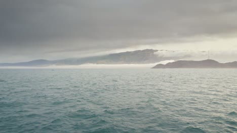 Toma-Cinematográfica-De-Un-Hombre-Parado-Sobre-Rocas-En-El-Mar