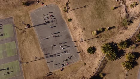 Draufsicht-Nach-Unten-Drohnenflug-über-Menschen,-Die-Auf-Einem-Feld-Handball-Spielen