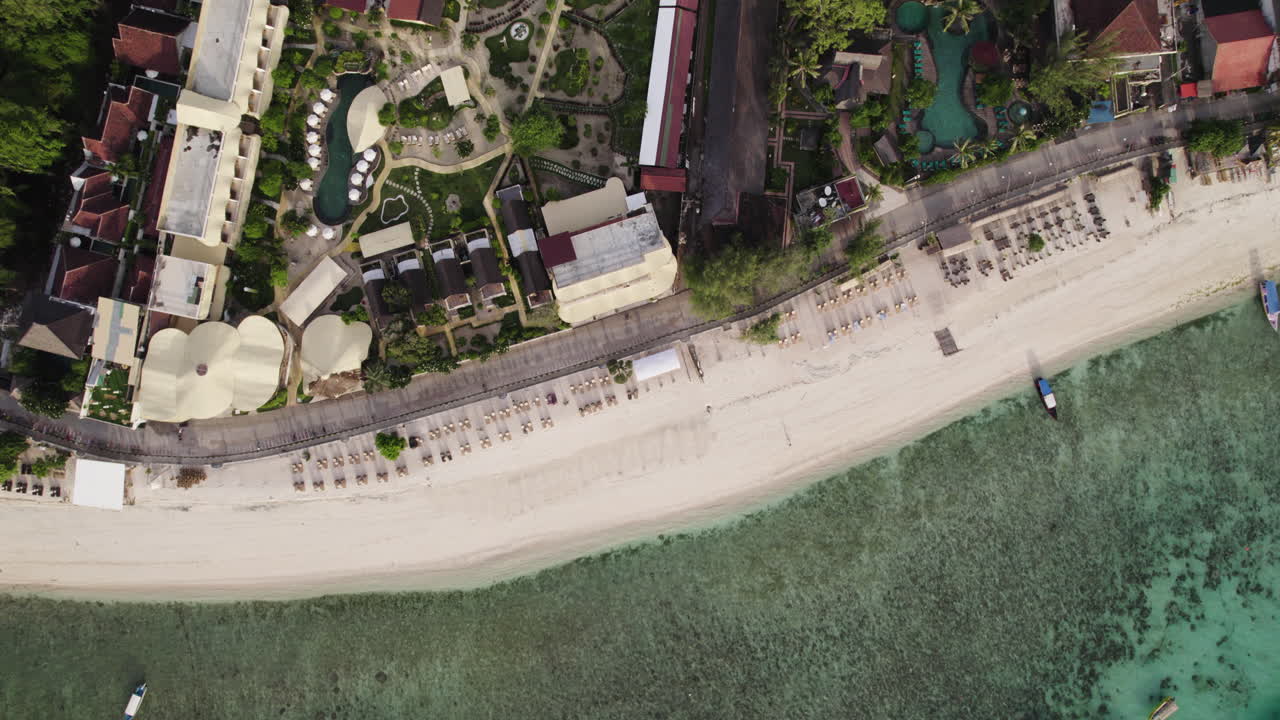 Top down drone shot over beach resorts on Gili Trawangan, sunny Indonesia