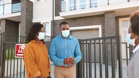 female real-estate selling house to african american happy couple and passing keys