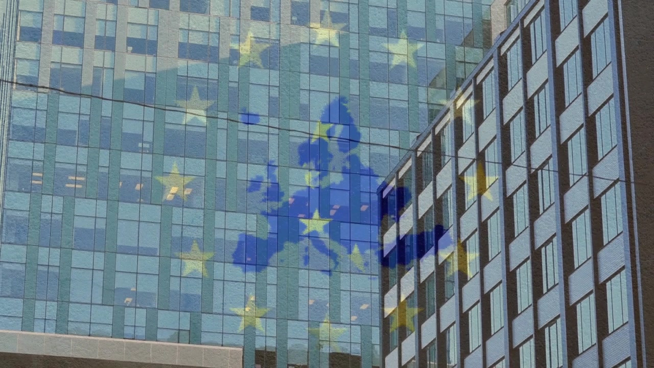After static shot blue Europe map projecting on glass tower, golden stars pulsing showing EU unity