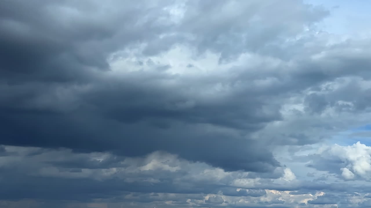 Dramatic dark cloudscape covering the sky. Low angle view at the clouds gathering in the atmosphere