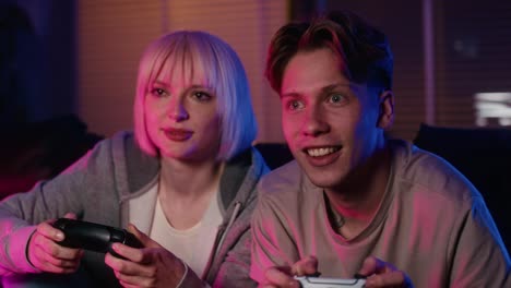 young caucasian couple playing video game with game pad