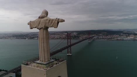 aerial view of lisbon cityscape showing christ the king statue and 25 de abril bridge over the tejo river by day in lisbon, portugal