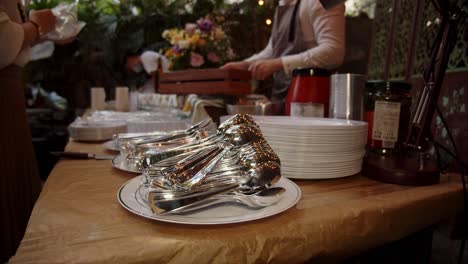 tiro medio de tenedores y cucharas de metal colocados en platos durante el catering de eventos sociales por la noche