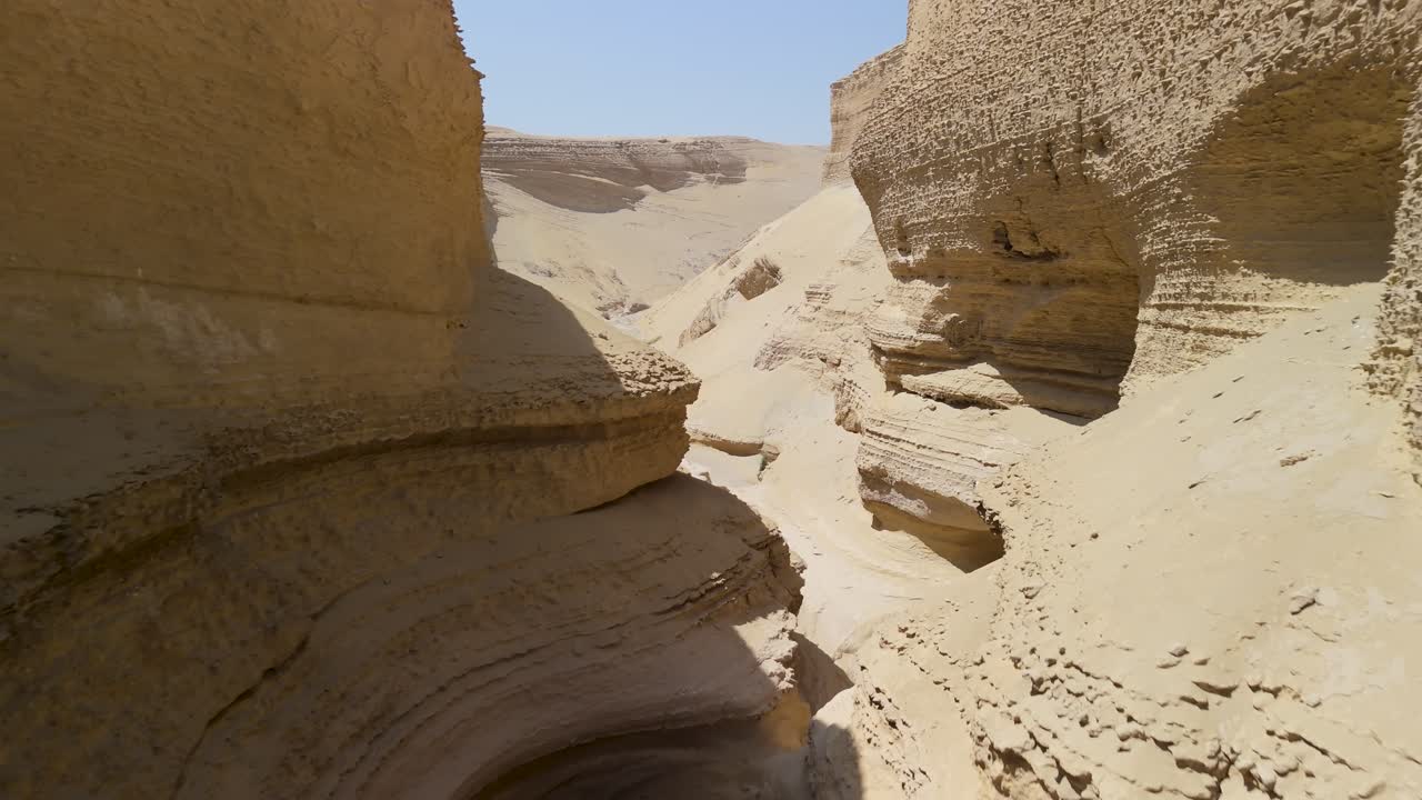 Dynamic flight through the narrow passages of Cañon de los Perdidos showcasing intricate sandstone layers, deep shadows and bright sunlight in the arid Ica desert of Peru