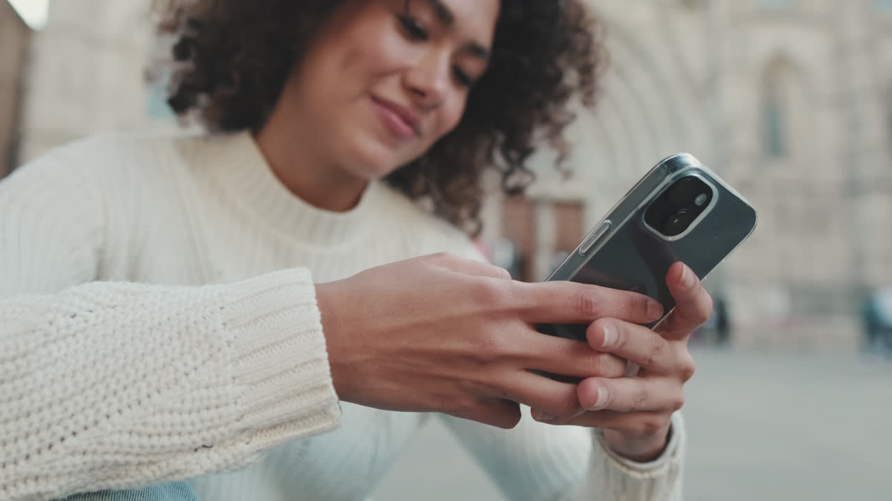 Kvinde bruger smartphone i urbane omgivelser