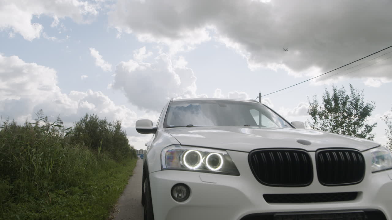 White SUV on a Road Under Cloudy Sky