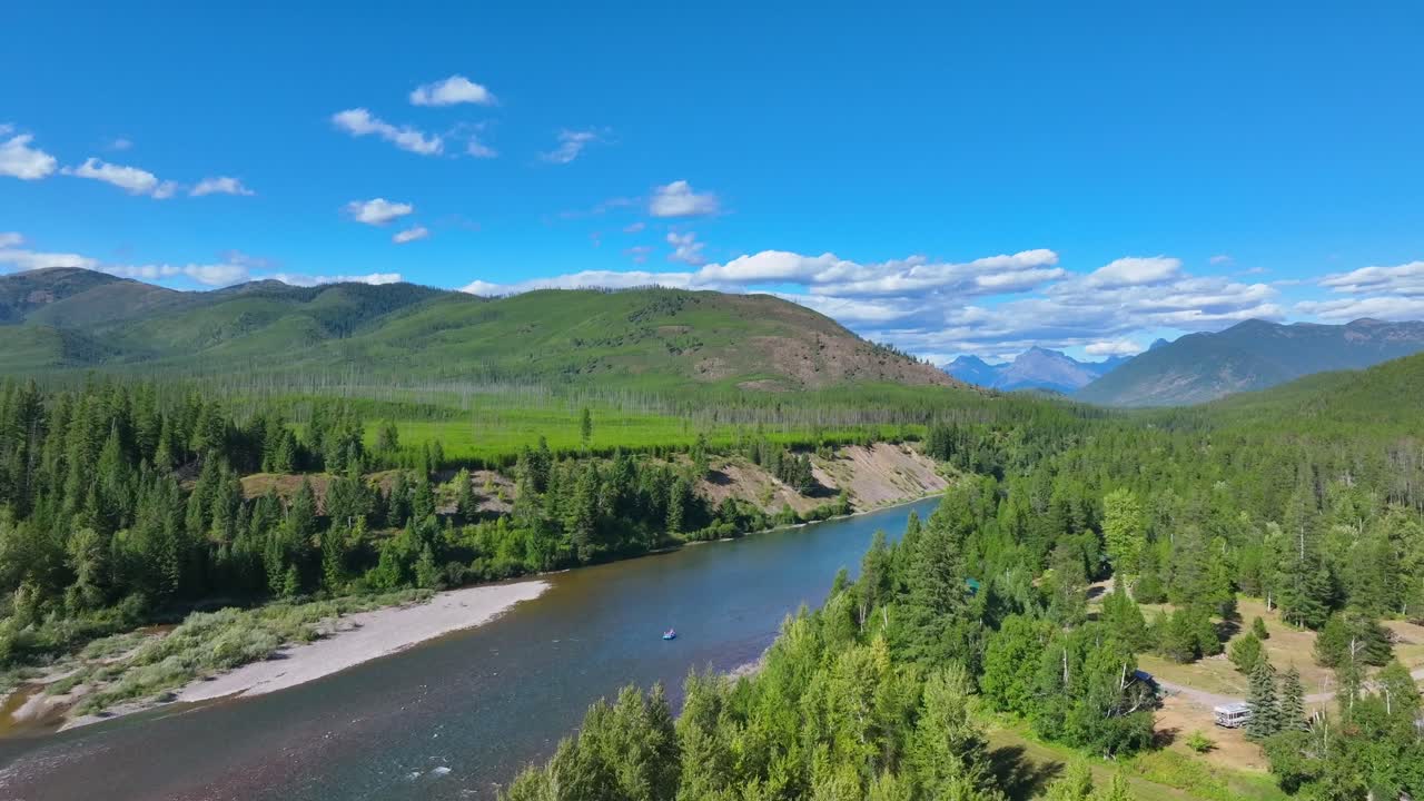 Flyver mod Flathead River med en flydende tømmerflåde nær Glacier National Park i Montana, USA