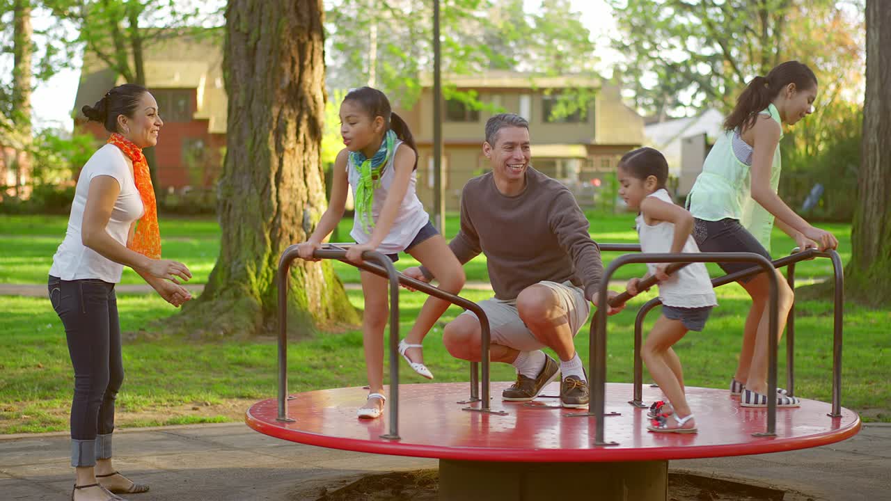 familia jugando en un carrusel en un parque