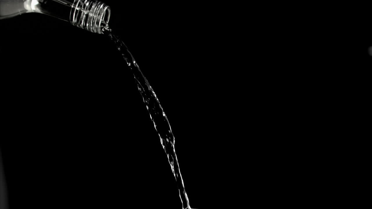 Rivolo d'acqua in super slow motion che scorre dal collo di bottiglia di vetro