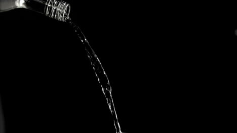 trickle of water in a super slow motion flowing of the glass bottleneck