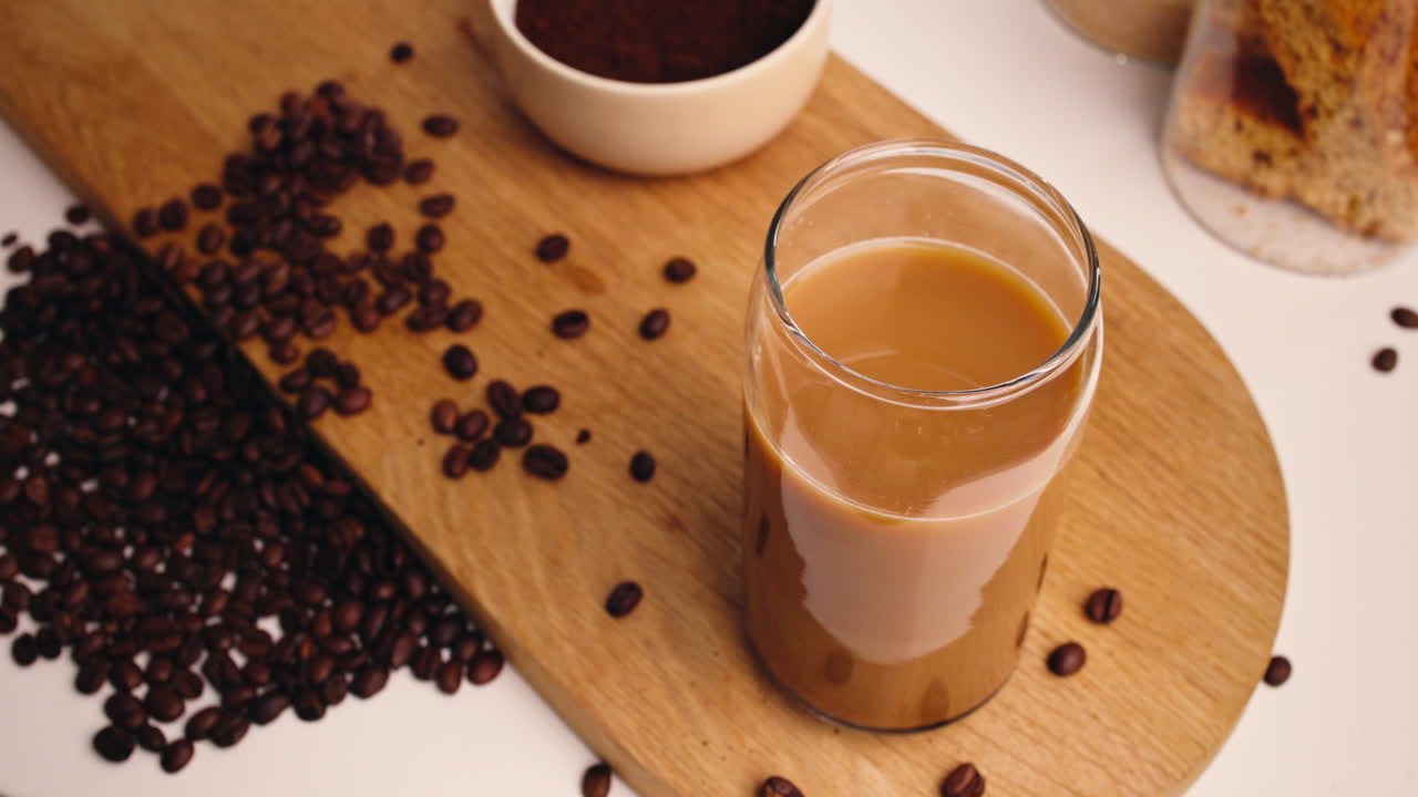 Tazza di caffè con latte e chicchi su tavola di legno