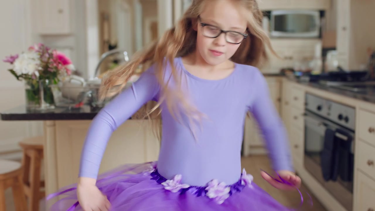 Bambina che Balla in Cucina con un Tutù Viola