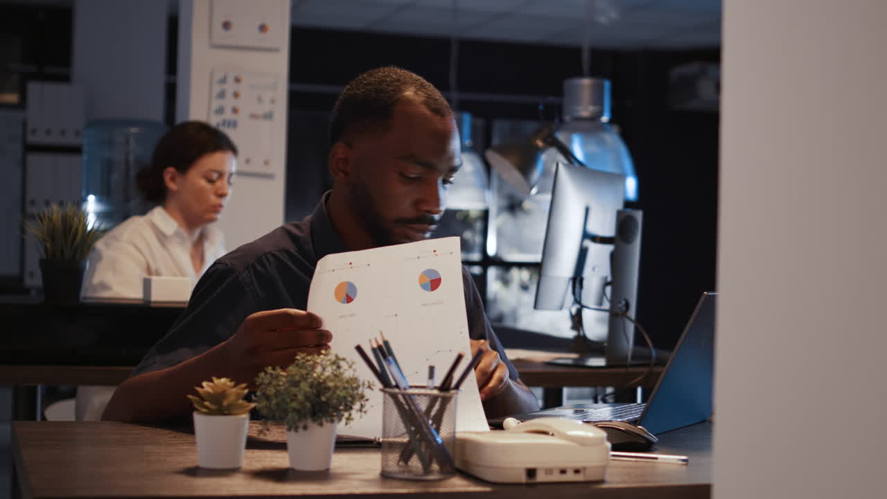 Male manager analyzing documents with sales sharing and investment