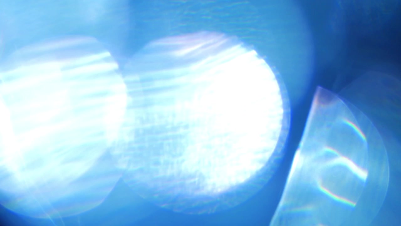 Vazamentos abstratos de luz azul e reflexos de lente em fundo escuro