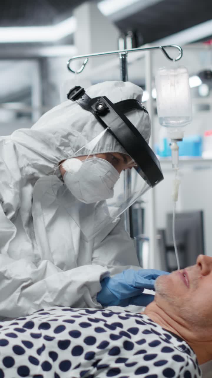 Vertical Video Doctors in hazmat suit doing examination on a patient with viral symptoms