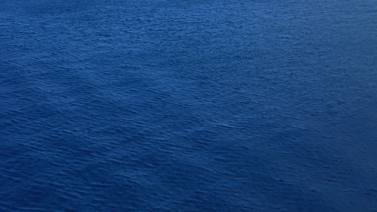 Increspature mosse dal vento si estendono sulle correnti delle acque profonde e blu dell'oceano Caraibico.