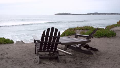 beautiful view of the ocean, two wooden chairs and table by the bay