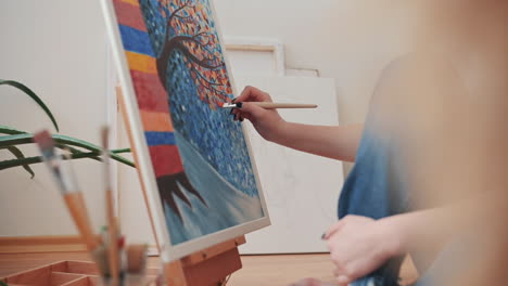 las manos de una mujer irreconocible pintando un lienzo colorido 1