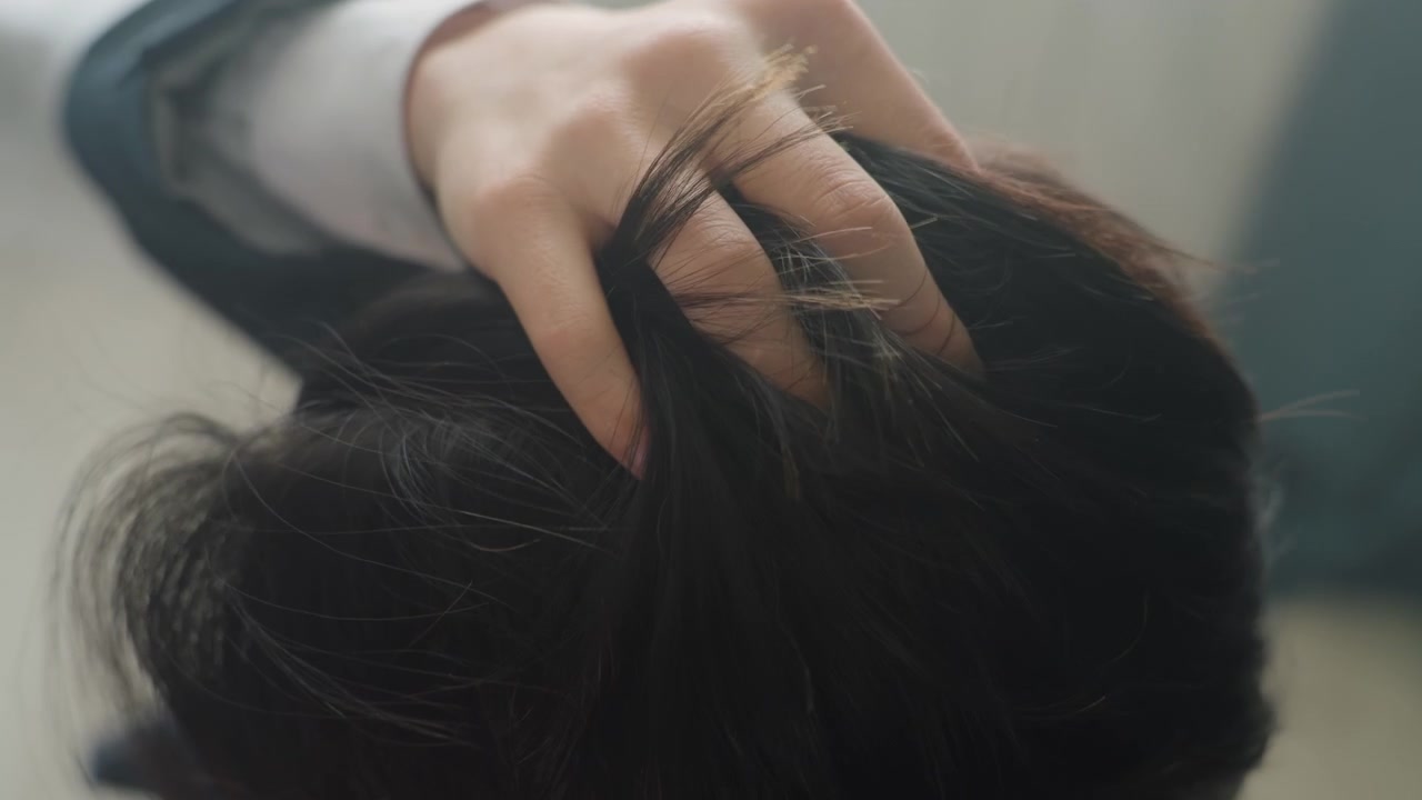 Pemeriksaan kulit kepala jarak dekat oleh profesional berjas. Rambut gelap di bawah cahaya alami jendela, jari-jari membelah rambut, memeriksa ketombe dan kekeringan, kecemasan dan ketegangan halus terlihat dalam gestur, pagi hari
