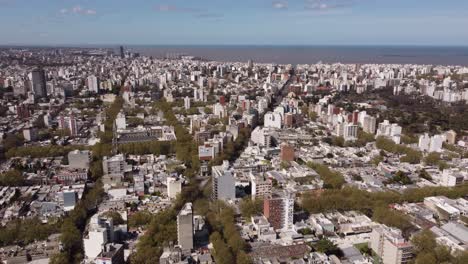 Sobrevuelo-Aéreo-Del-Paisaje-Urbano-De-Montevideo-Con-El-Océano-De-Fondo-Durante-El-Día-Soleado,-Uruguay