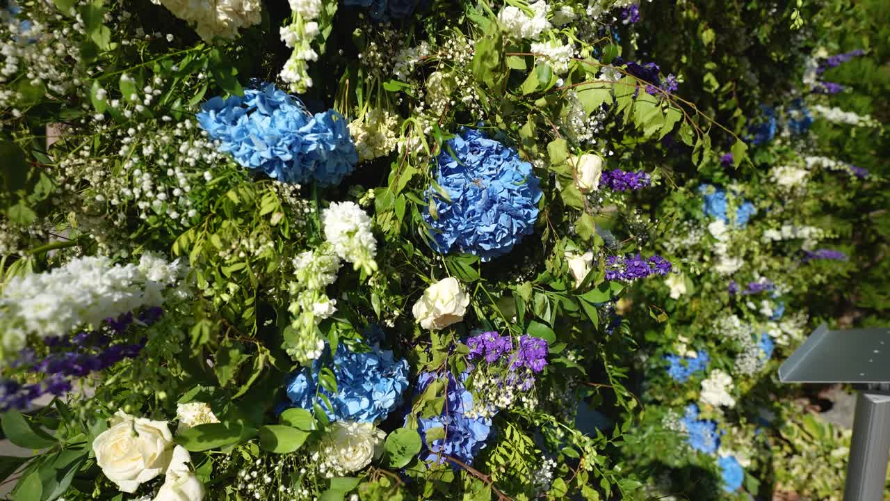 느린 동작으로 그려진 그림은 활기찬 꽃으로 구성된 숨길만한 아치입니다.