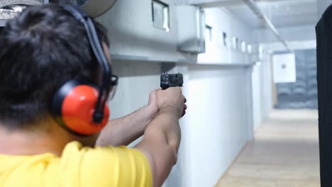 Man practicing shooting at an indoor range