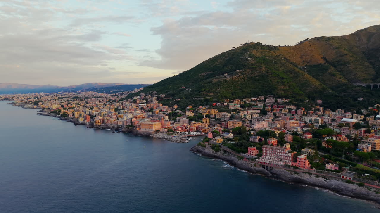 Tramonto dorato a Genova, Italia, edifici colorati, vista aerea sul mare sereno