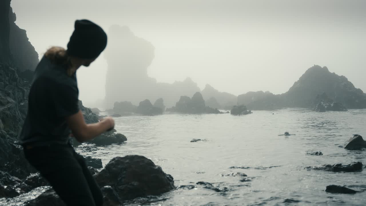 젊은 밀레니얼 세대 z 남성이 어두운 안개가 가득한 수영장에서 바위를 뛰어넘습니다.