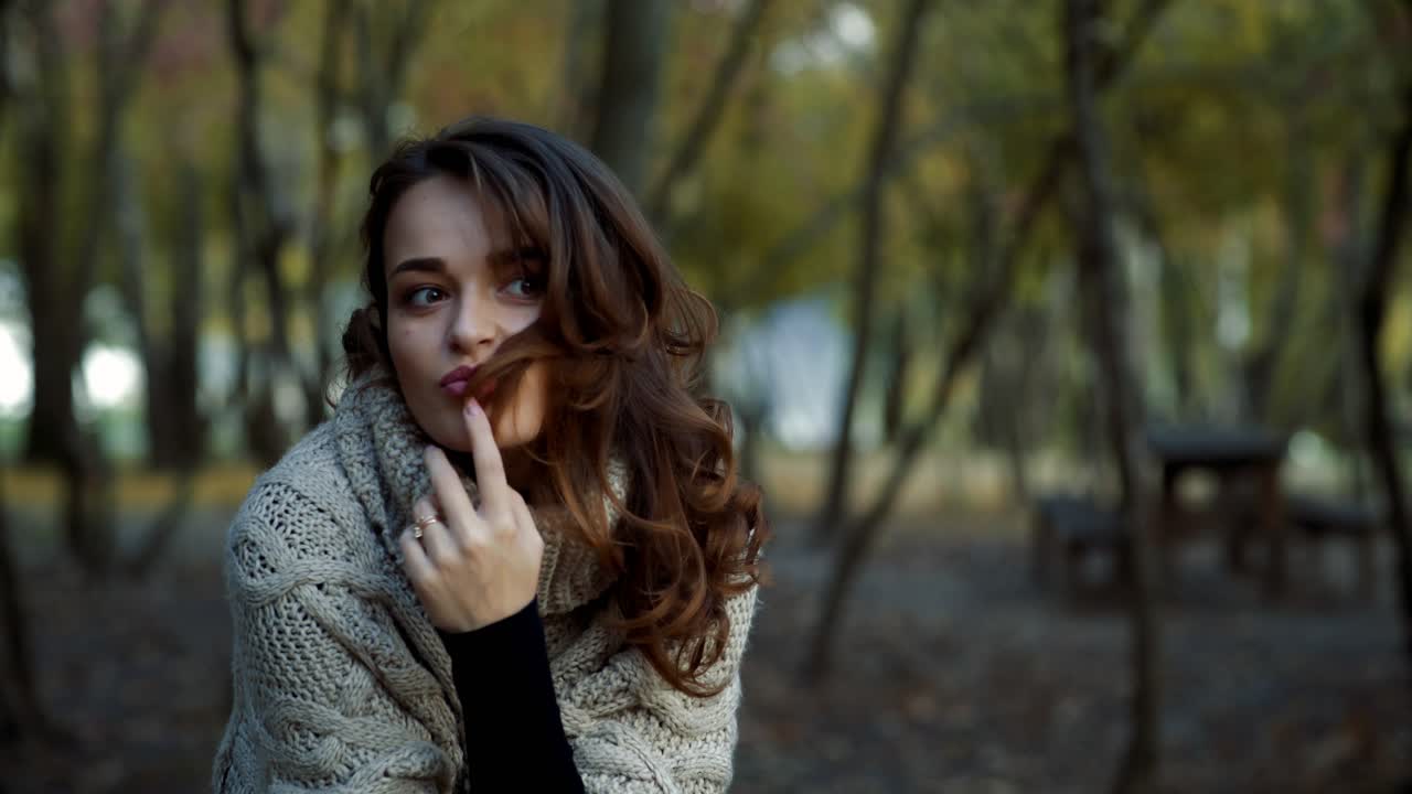 Woman relaxing in park. Happy attractive woman relaxing in sunny autumn park