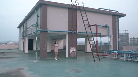 relaxed lady walks on roof past hotel service equipment